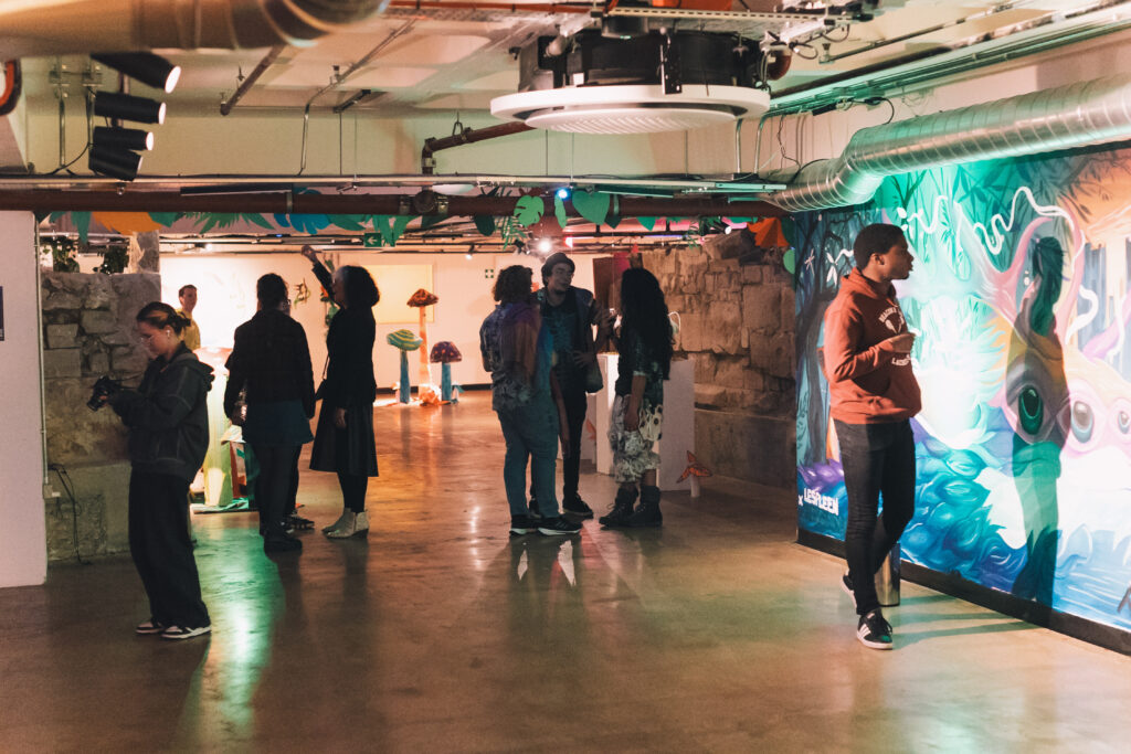 Visitors look at murals on the walls of FUSEBOX